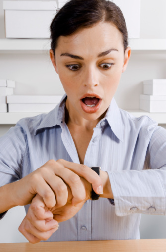 Gasping businesswoman looking at watch
